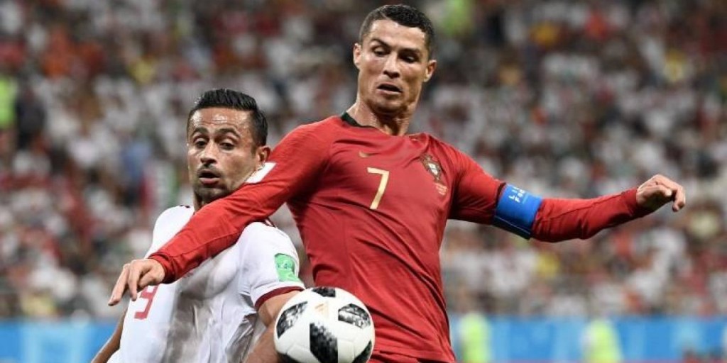 Cristiano Ronaldo pugna por el balón con un jugador iraní