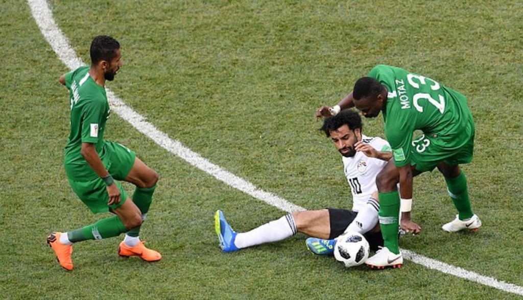 Salah en el suelo rodeado por dos rivales de Arabia Saudí